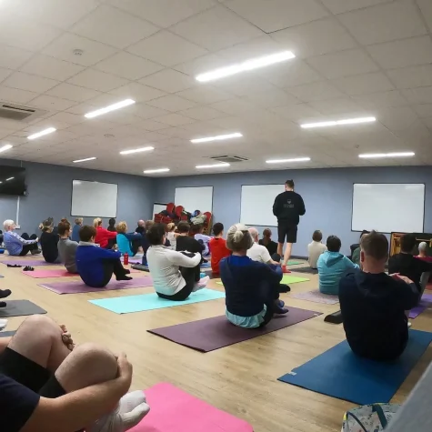 Ian teaching a large seated movement class